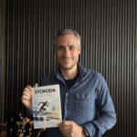 Авторът Стойчо Коджабашев, усмихнат, с книгата „STOKODA Архитектура на представянето“ в ръце