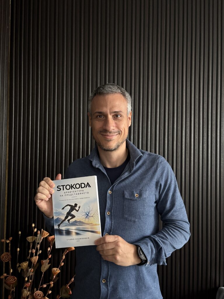 Авторът Стойчо Коджабашев, усмихнат, с книгата „STOKODA Архитектура на представянето“ в ръце